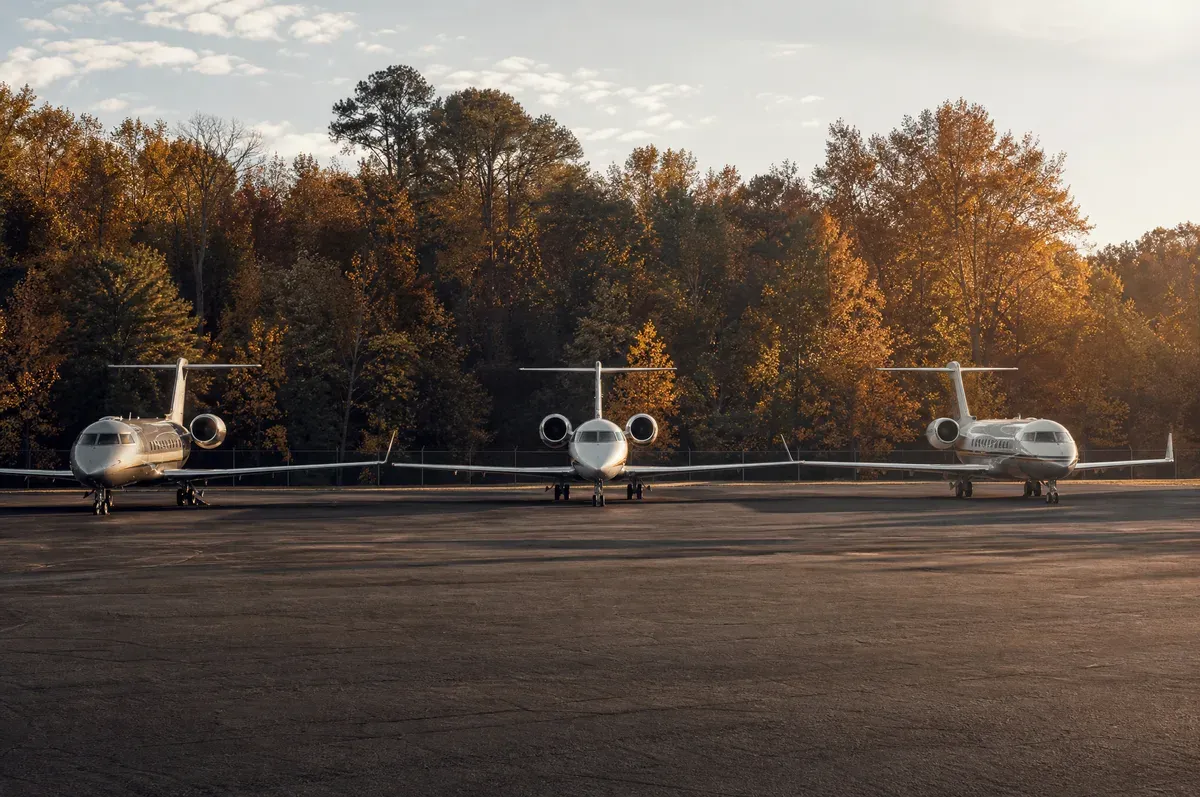 A tidy corporate ramp bordered by woodland with jets in an evenly spaced row