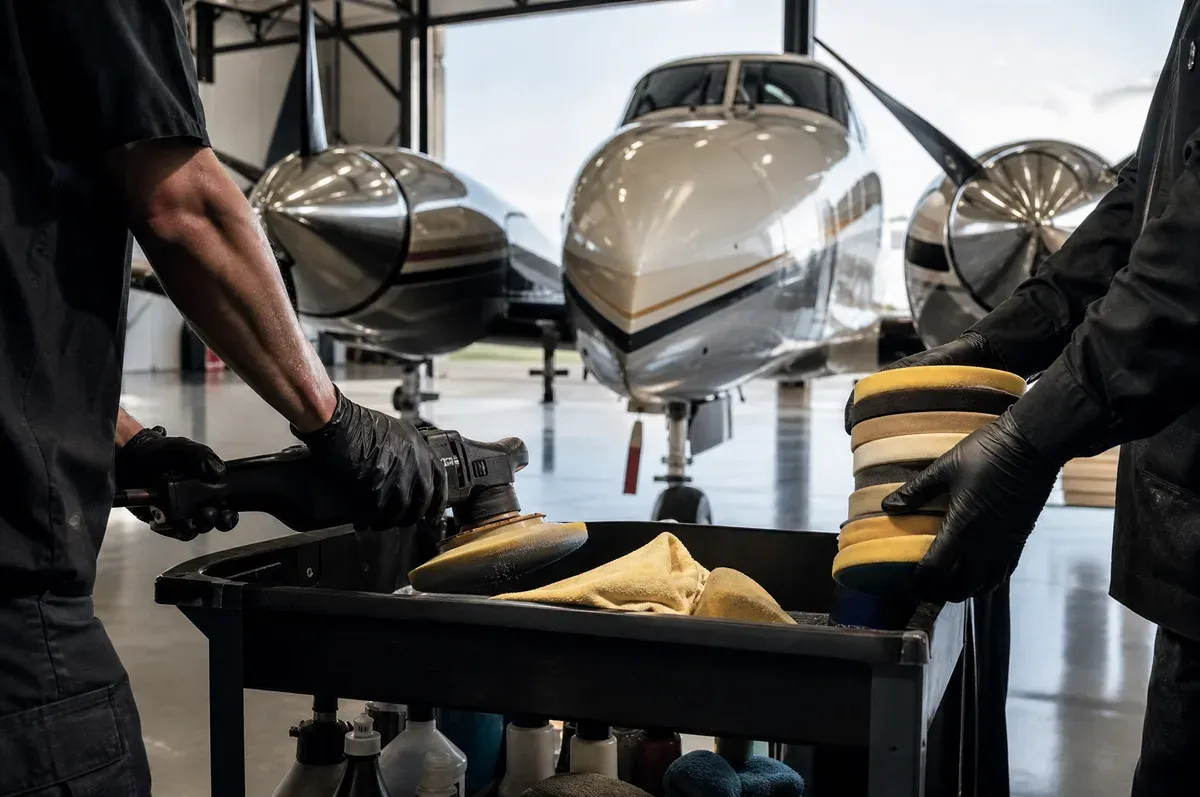 Equipment unloaded from a cart in a hangar beside a twin turboprop