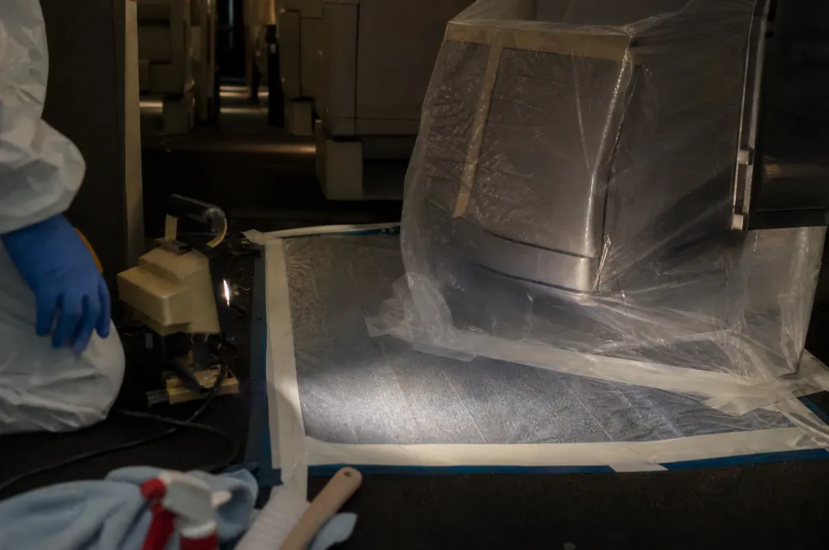 A contained section of jet cabin sealed with sheeting under a work light